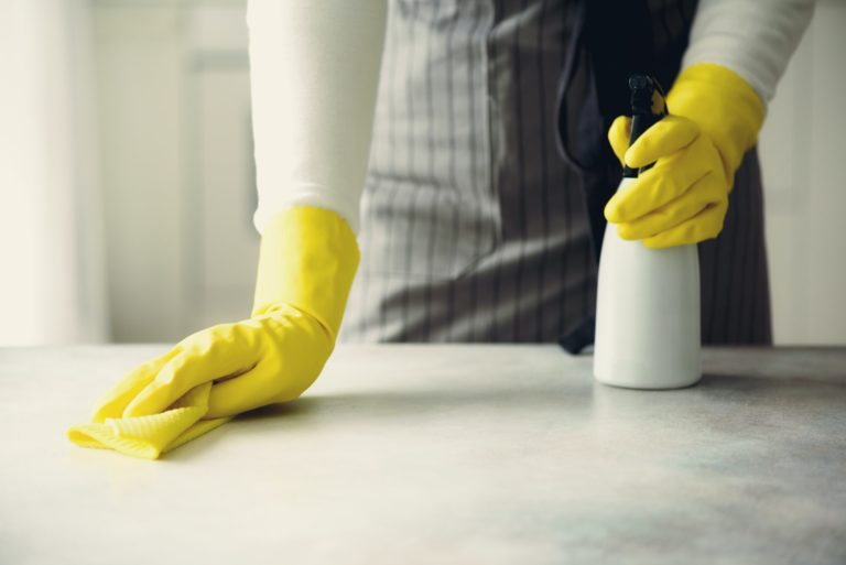 Woman in yellow rubber protective gloves wiping dust and dirty. Cleaning concept, banner, copy space